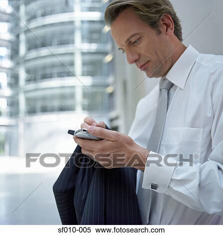 Stock Photography - Businessman using palmtop. Fotosearch