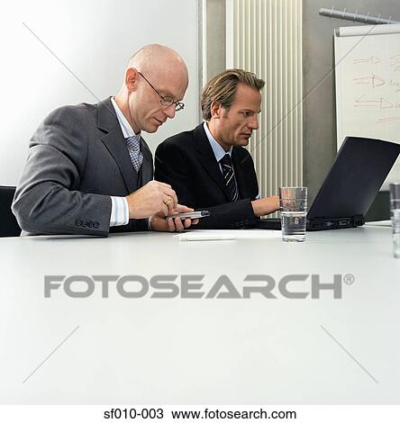 Businessmen using laptop and palmtop View Large Photo Image Stock Image - Businessmen using laptop and palmtop. Fotosearch