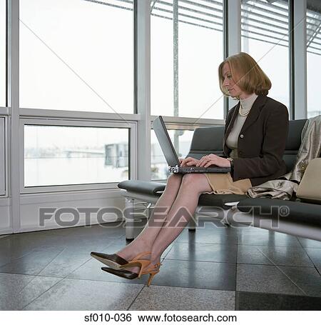 Businesswoman using laptop in departure lounge View Large Photo Image Stock Photograph - Businesswoman using laptop in departure lounge. Fotosearch