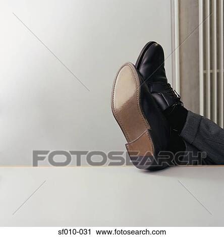 Stock Image - Feet up on a desk. Fotosearch