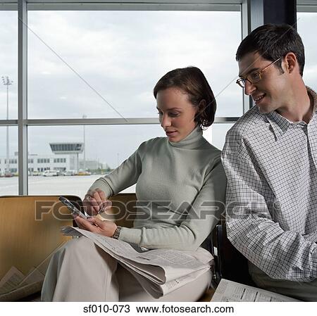 Stock Image - Two colleagues in a departure lounge. Fotosearch