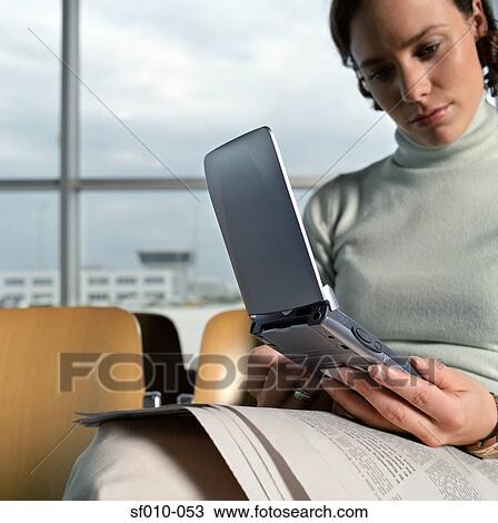 Woman using palmtop in departure lounge View Large Photo Image Stock Image - Woman using palmtop in departure lounge. Fotosearch