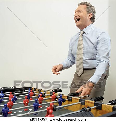 Businessman playing table football View Large Photo Image Stock Photo - Businessman playing table football. Fotosearch
