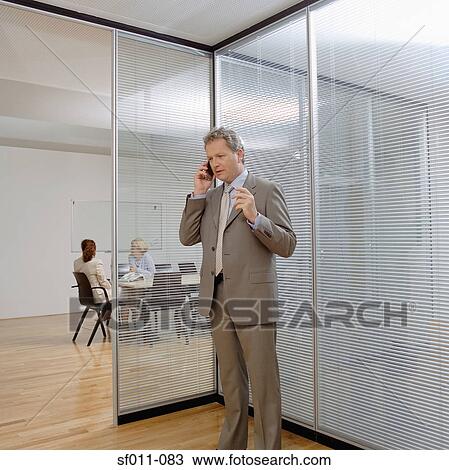 Stock Image - Businessman using a cellular telephone. Fotosearch