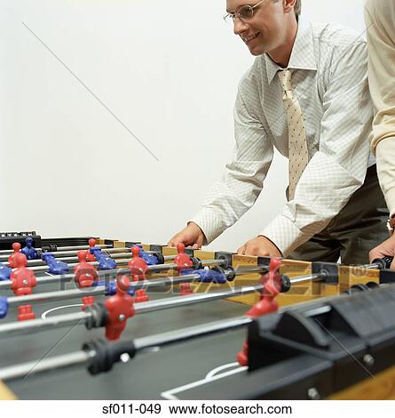 Stock Photo - Businessmen playing table football. Fotosearch