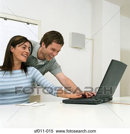 Colleagues using a laptop computer View Large Photo Image Stock Photography - Colleagues using a laptop computer. Fotosearch