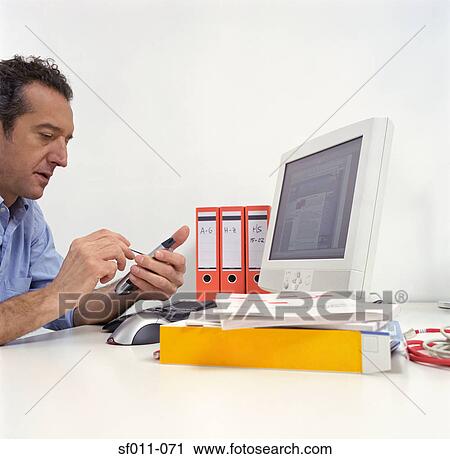 Stock Image - Office worker using a handheld computer. Fotosearch