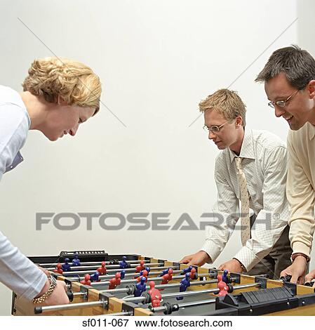 Office workers playing table football View Large Photo Image Stock Photo - Office workers playing table football. Fotosearch