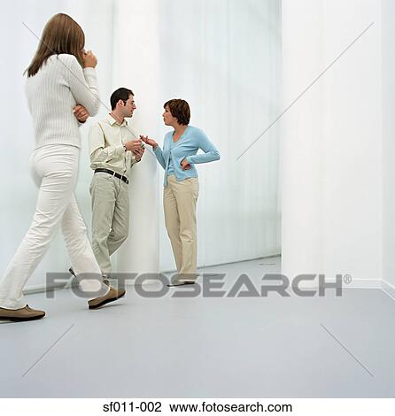 Stock Image - Office workers talking in corridor. Fotosearch
