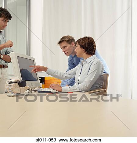 Three office workers at desk View Large Photo Image Stock Photo - Three office workers at desk. Fotosearch