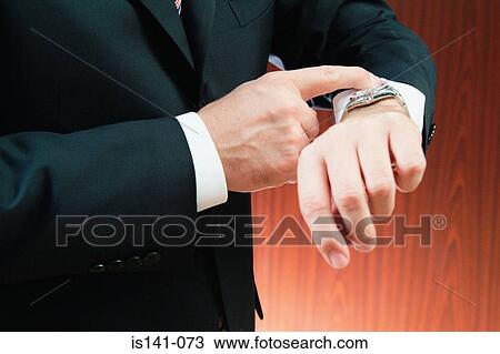 Businessman checking the time View Large Photo Image Stock Image - Businessman checking the time. Fotosearch
