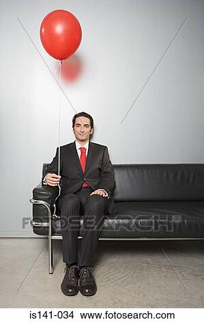 Businessman holding a balloon View Large Photo Image Picture - Businessman holding a balloon. Fotosearch