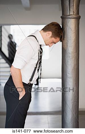 Stock Photo - Businessman leaning against a pole. Fotosearch