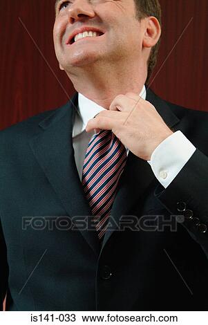 Stock Image - Businessman loosening collar. Fotosearch