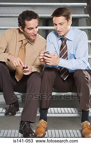 Colleagues comparing mobile phones View Large Photo Image Stock Image - Colleagues comparing mobile phones. Fotosearch