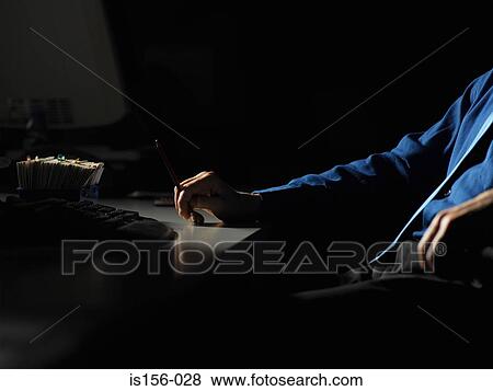 Man at his desk in the dark View Large Photo Image Stock Photo - Man at his desk in the dark. Fotosearch