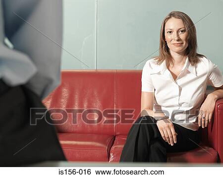 Office worker sitting on a sofa View Large Photo Image Stock Photograph - Office worker sitting on a sofa. Fotosearch