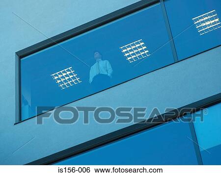 Stock Photograph - View of businessman through a window. Fotosearch