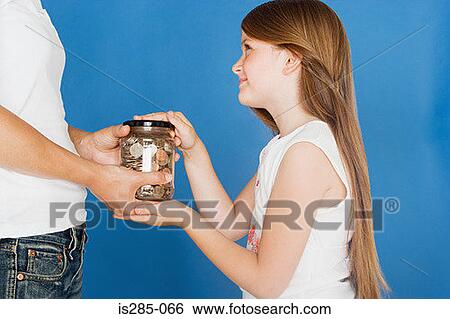 Stock Photograph - Girl handing jar of coins to mother. Fotosearch