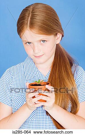 Girl holding plant in a pot View Large Photo Image Picture - Girl holding plant in a pot. Fotosearch