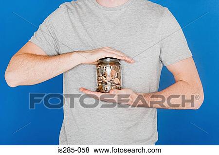 Man holding a jar of coins View Large Photo Image Stock Photo - Man holding a jar of coins. Fotosearch