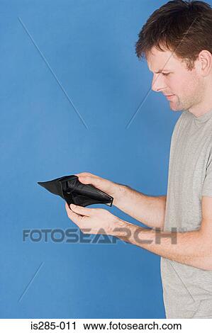 Stock Image - Man holding empty wallet. Fotosearch