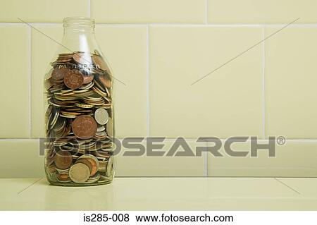 Stock Photo - Milk bottle full of coins. Fotosearch