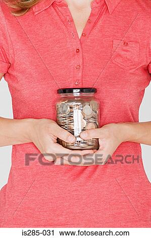 Woman holding a jar of pennies View Large Photo Image Stock Image - Woman holding a jar of pennies. Fotosearch