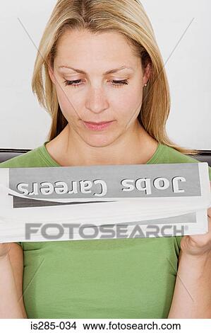Picture - Woman reading a recruitment newspaper. Fotosearch