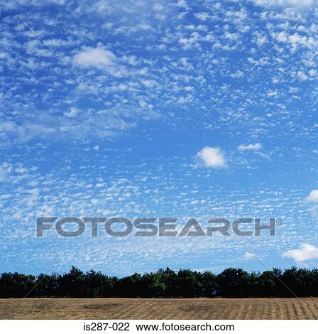 Stock Image - Clouds above a field. Fotosearch