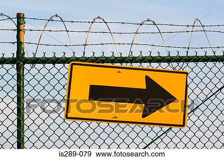 Stock Photo - Arrow sign on a fence. Fotosearch