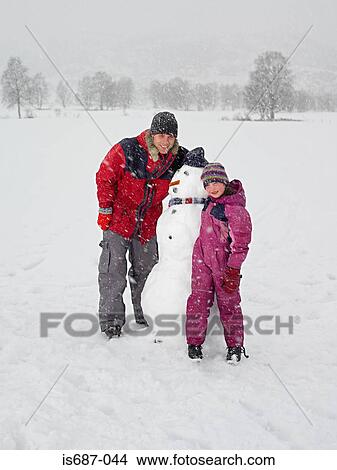 Picture - Father and daughter with snowman. Fotosearch