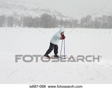 Stock Photo - Girl on skis walking in the snow. Fotosearch