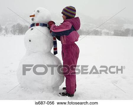 Girl tying scarf on snowman View Large Photo Image Stock Photograph - Girl tying scarf on snowman. Fotosearch