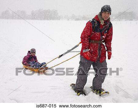 Man pulling his daughter in a sled View Large Photo Image Stock Photography - Man pulling his daughter in a sled. Fotosearch