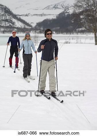 Skiers trekking through the snow View Large Photo Image Stock Photograph - Skiers trekking through the snow. Fotosearch