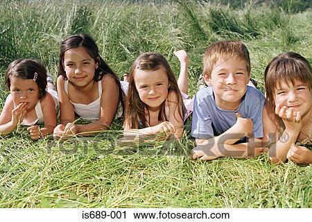 Stock Image - Friends lying in the grass. Fotosearch