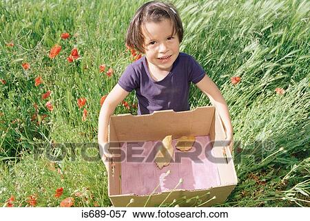 Stock Photo - Girl carrying a cardboard box with chicks in. Fotosearch