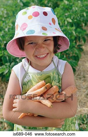 Girl holding carrots in her arms View Large Photo Image Stock Photograph - Girl holding carrots in her arms. Fotosearch