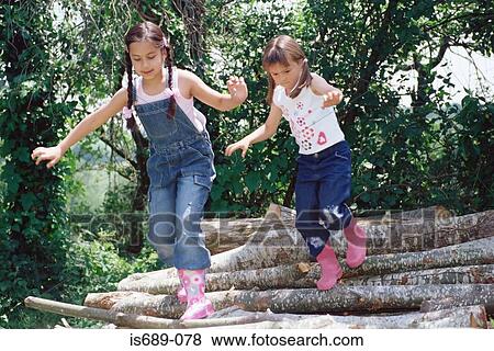 Girls running over logs View Large Photo Image Stock Photo - Girls running over logs. Fotosearch