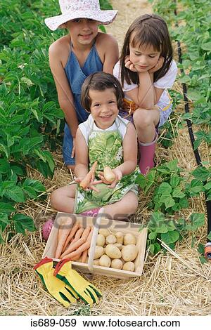 Stock Photo - Girls with a basket of vegetables. Fotosearch