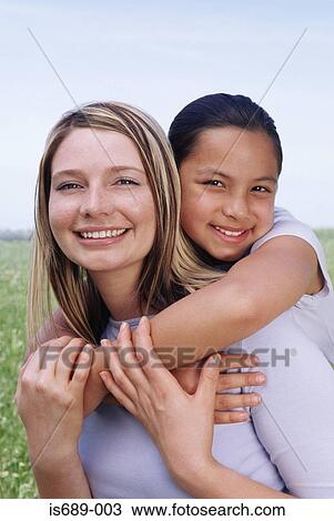Woman giving girl a piggyback View Large Photo Image Stock Image - Woman giving girl a piggyback. Fotosearch