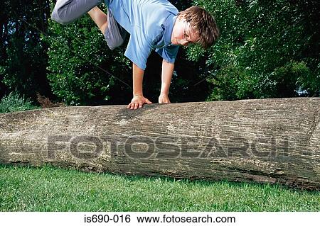 Stock Photograph - Boy jumping over a log. Fotosearch
