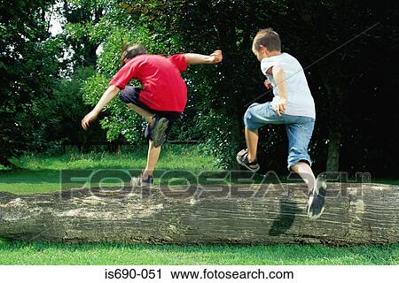 Boys jumping over a log View Large Photo Image Stock Image - Boys jumping over a log. Fotosearch