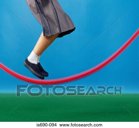 Girl jumping over skipping rope View Large Photo Image Picture - Girl jumping over skipping rope. Fotosearch