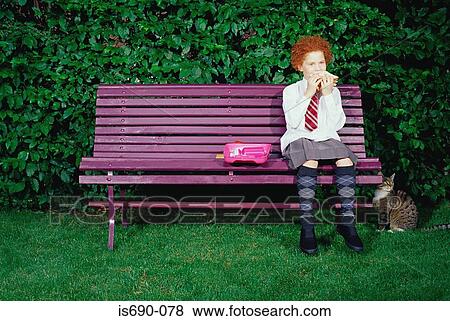 Girl on a bench eating a sandwich View Large Photo Image Stock Photo - Girl on a bench eating a sandwich. Fotosearch