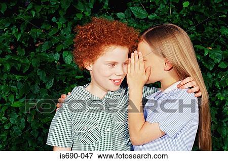 Girl whispering to her friend View Large Photo Image Stock Photo - Girl whispering to her friend. Fotosearch