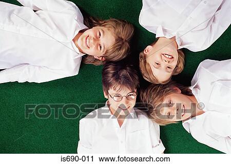 Stock Image - School friends lying on grass. Fotosearch