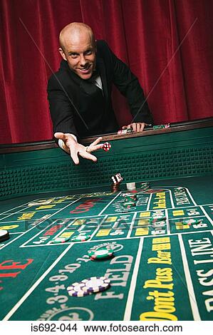 Man throwing dice at craps table Picture  is692-044 