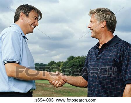 Stock Image - Golfers shaking hands. Fotosearch